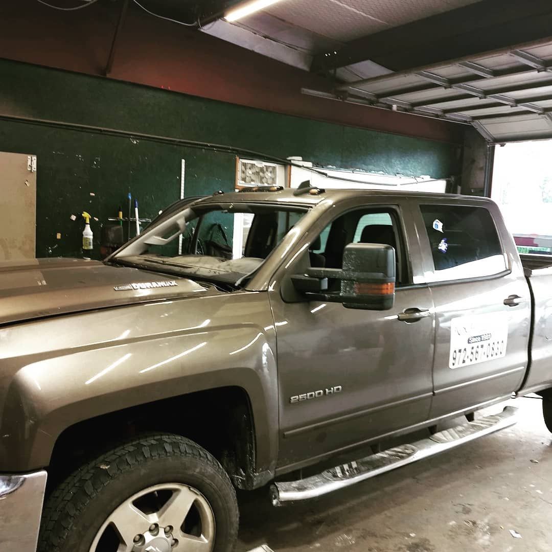 A gray truck is parked in a garage.