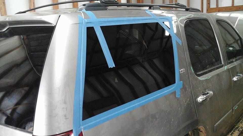 A silver suv is taped together with blue tape