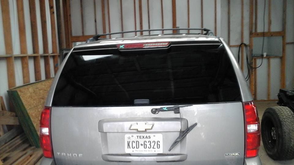 A silver suv with a texas license plate is parked in a garage