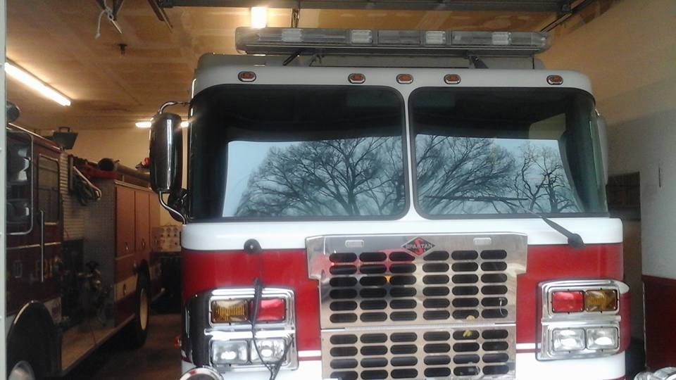 A red and white fire truck is parked in a garage.