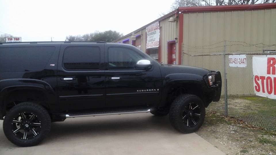 A black suv is parked in front of a building.