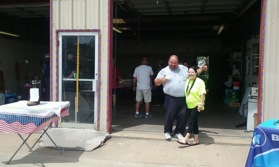 A man and a woman are standing in front of a garage door.