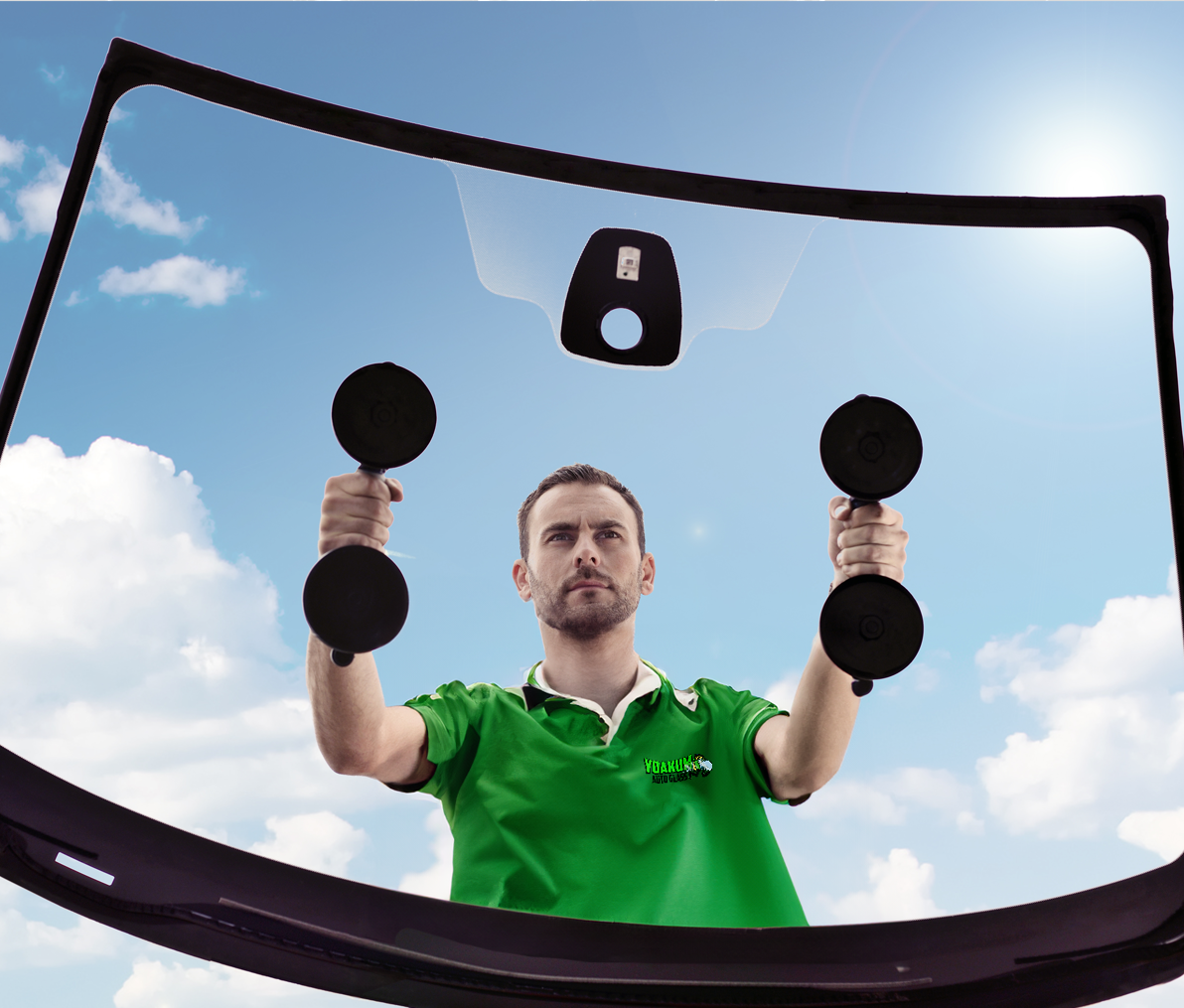 A man in a green shirt is installing a windshield.