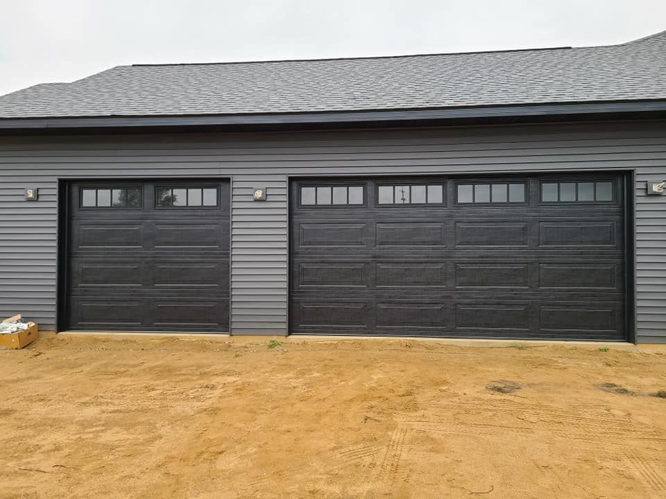 There are two garage doors on the side of a house.