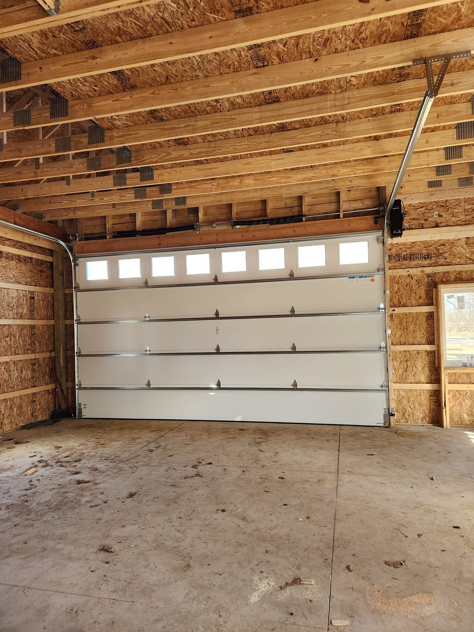 A garage door is open in a building under construction.