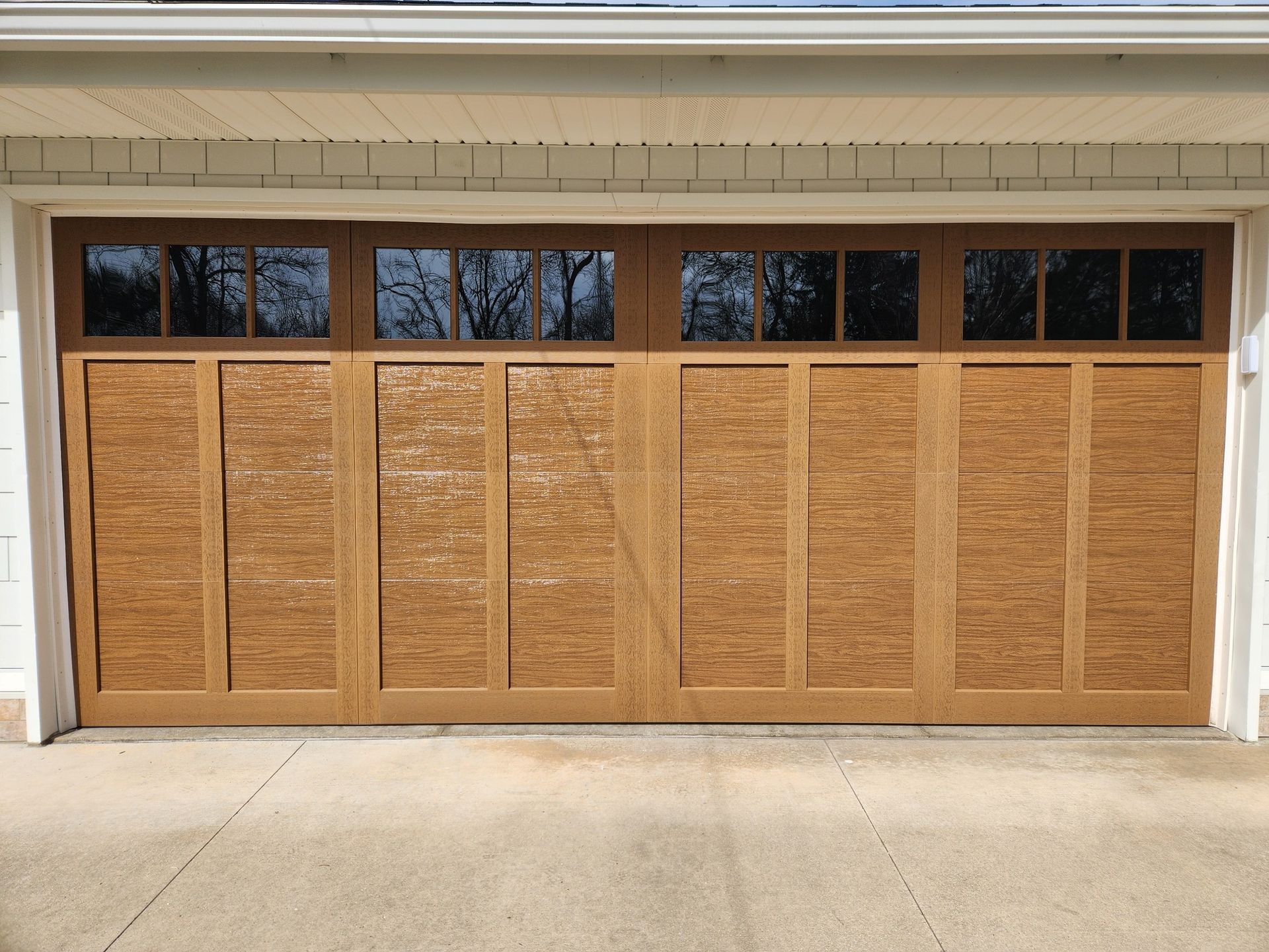 A large wooden garage door with a lot of windows