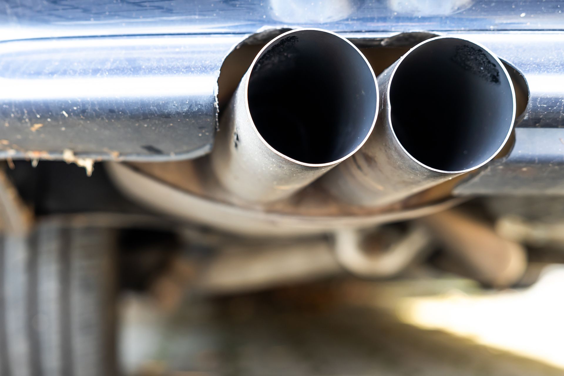 An exhaust pipe of a car showing signs of wear, indicating the need for auto exhaust services.