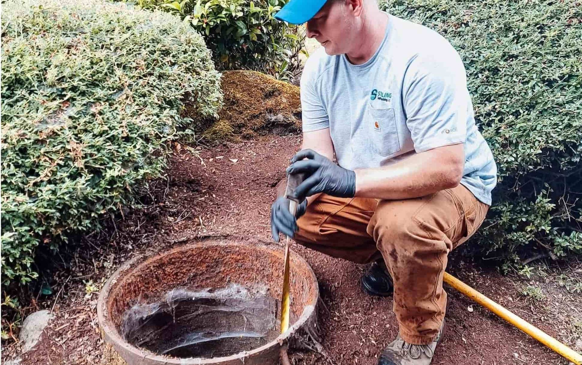 Technician inspecting outdoor septic tank for signs of being full — Sterling Septic & Plumbing