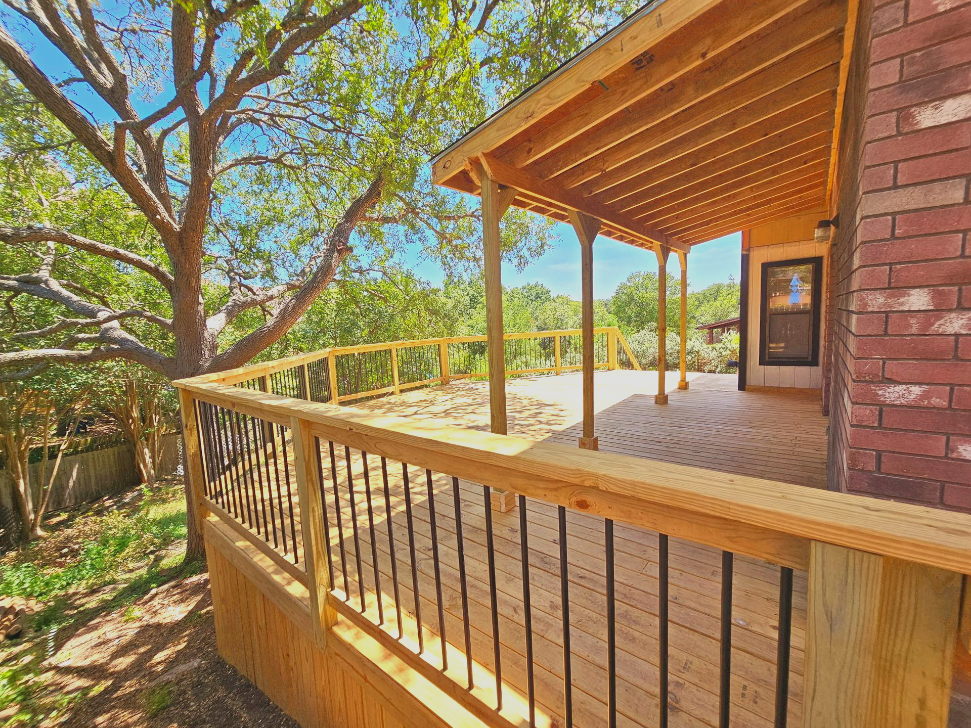 Wooden fence, cedar colored planks, with horizontal support beams.