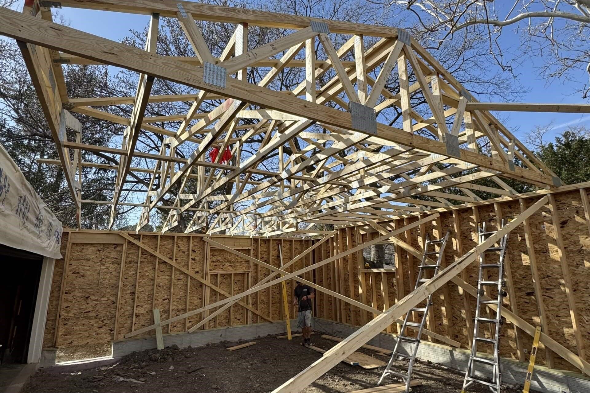 A man is standing in the middle of a wooden structure under construction.