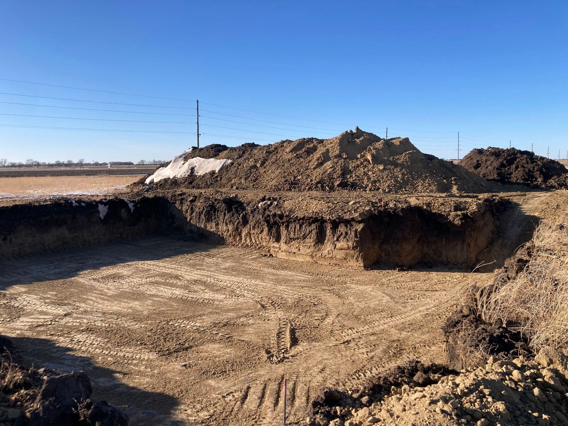 A large pile of dirt is sitting in the middle of a dirt field.