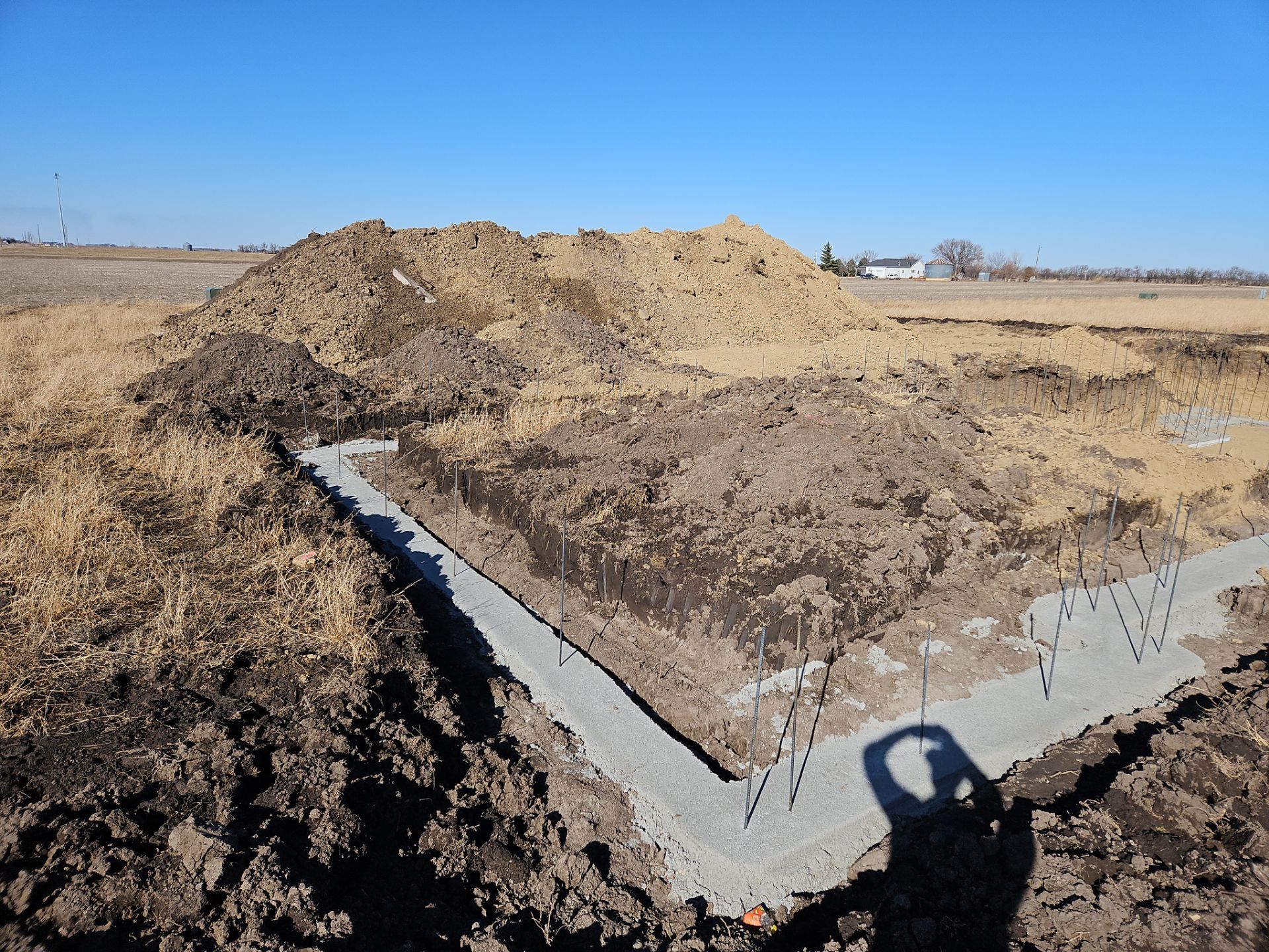A large pile of dirt is sitting in the middle of a field.