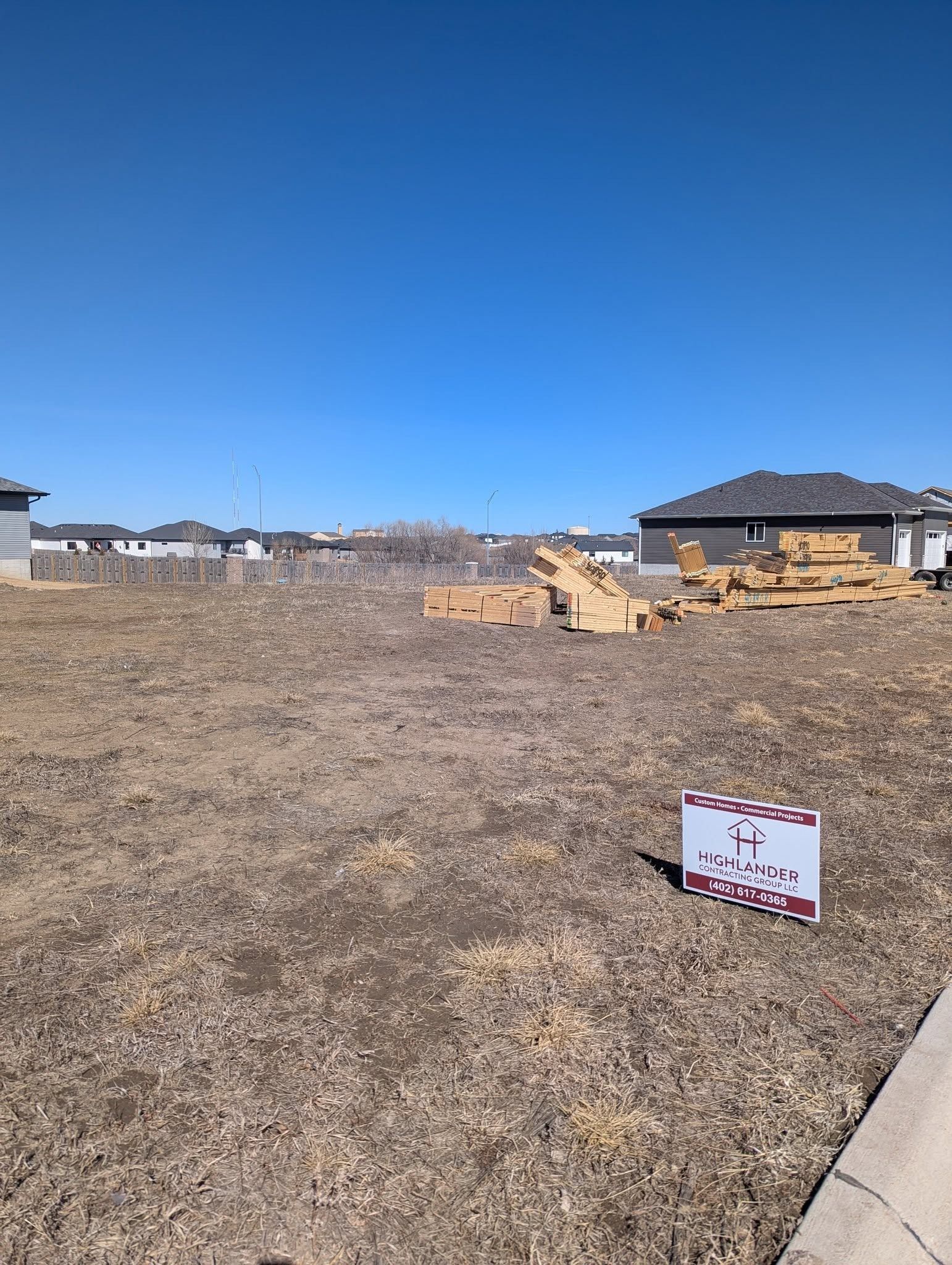 A lot with a for sale sign in the middle of it.