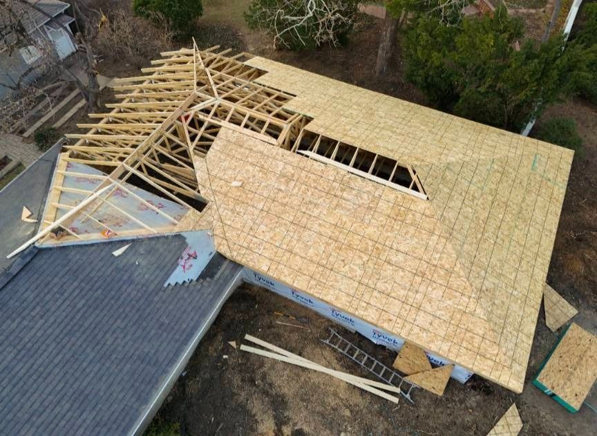 An aerial view of a house under construction with a wooden roof.