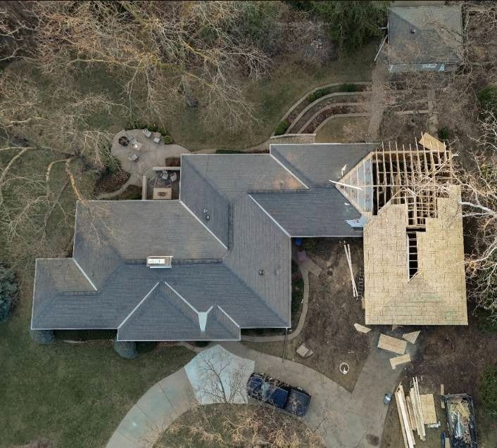 A man is standing in the middle of a wooden structure under construction.