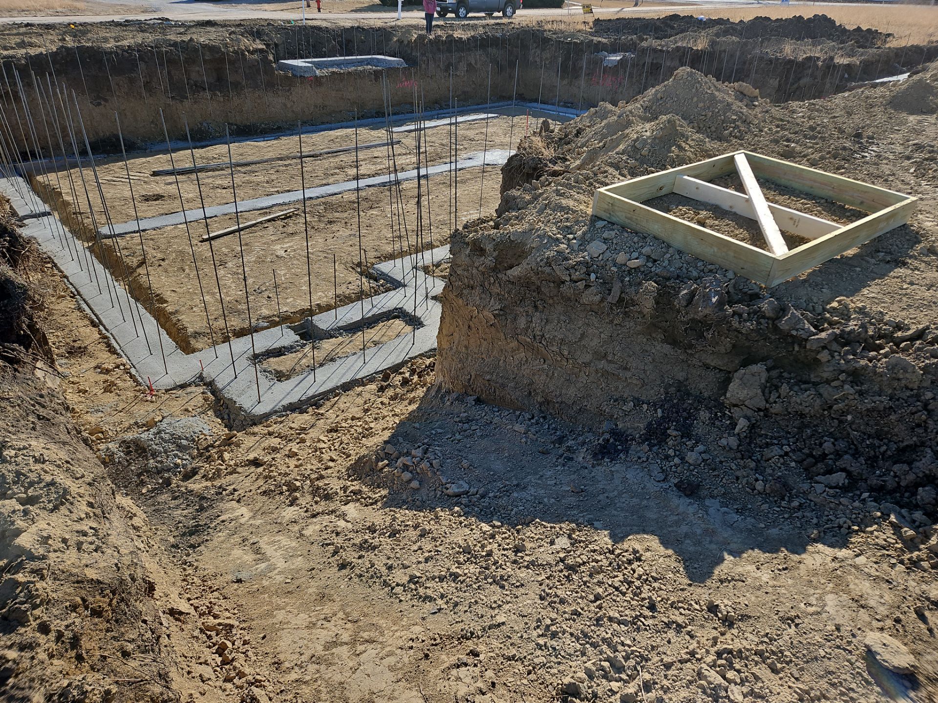 The foundation of a house is being built in the dirt.