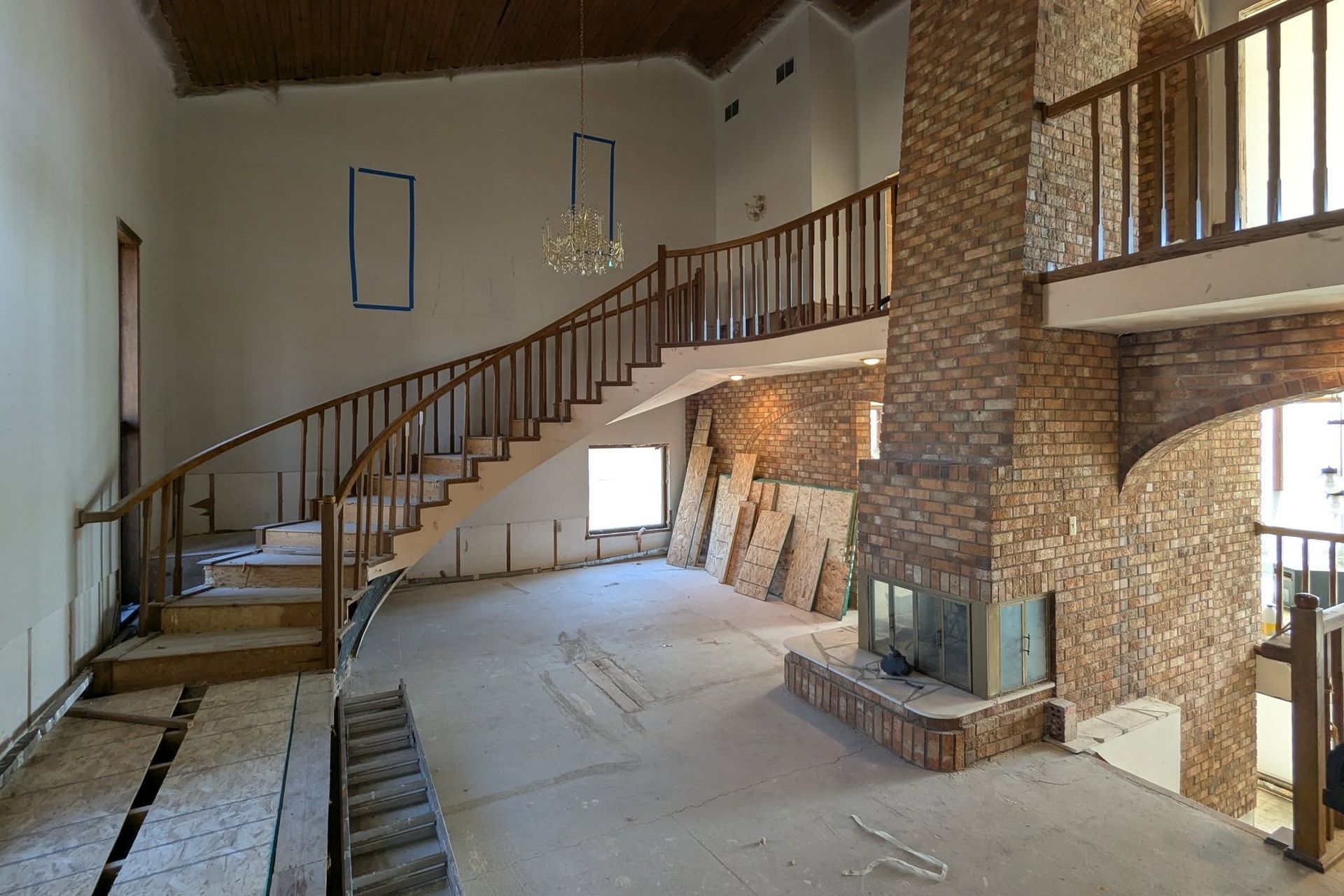 A large empty room with stairs and a fireplace