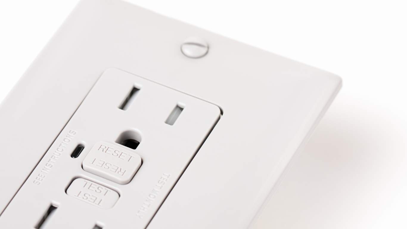 A close up of a white gfci outlet on a white wall.