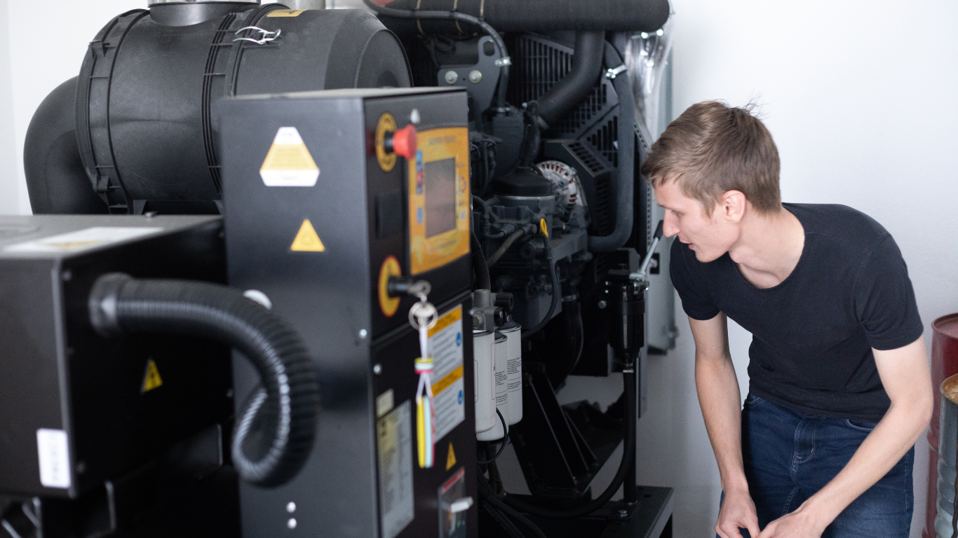 A man in a black shirt is working on a generator.