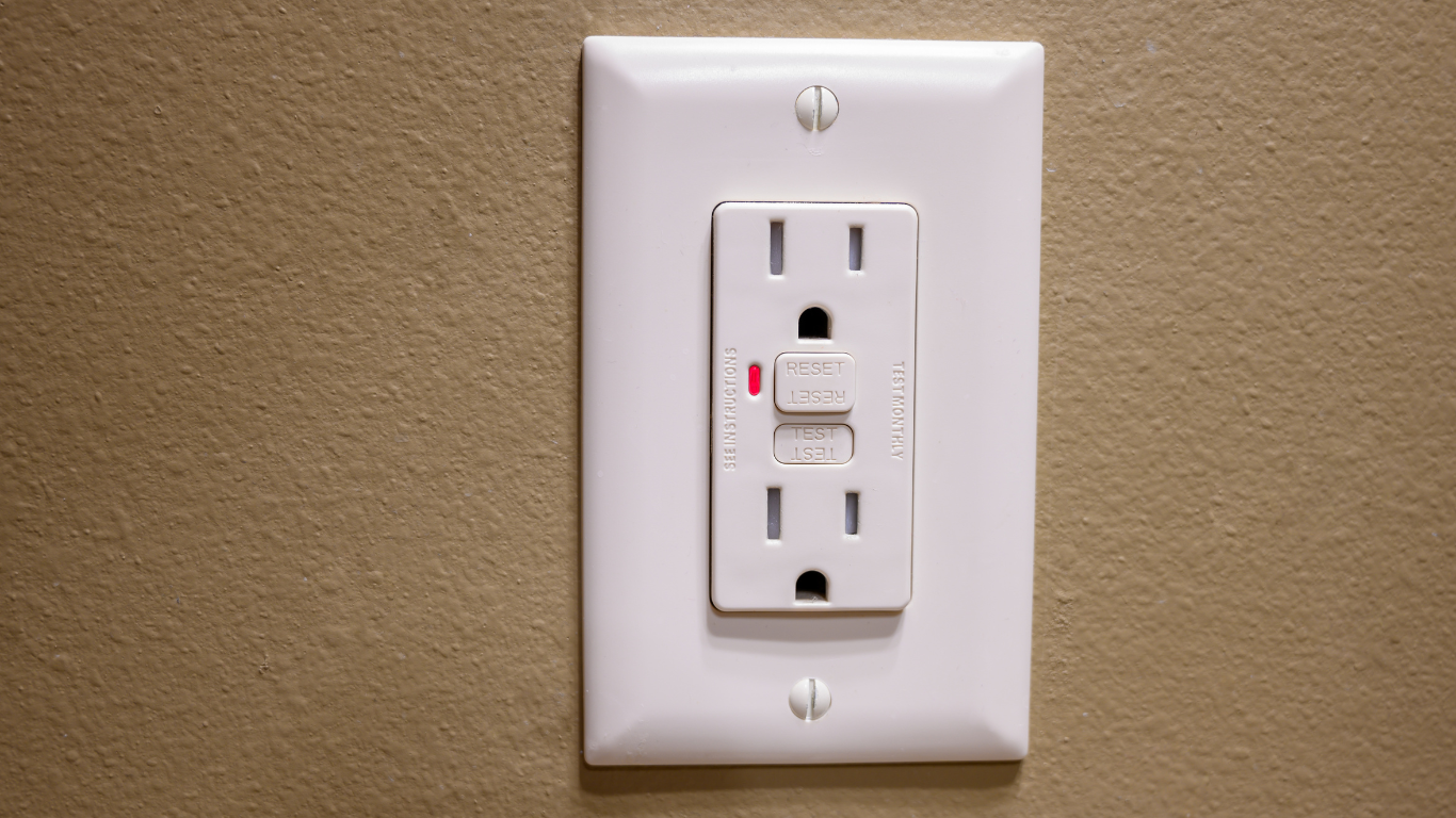 A computer mouse is sitting on a desk next to a power strip.