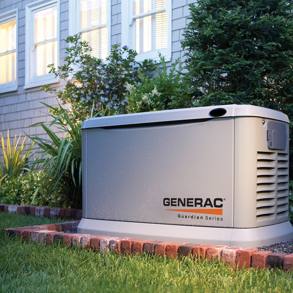 A generator is sitting in the grass in front of a house