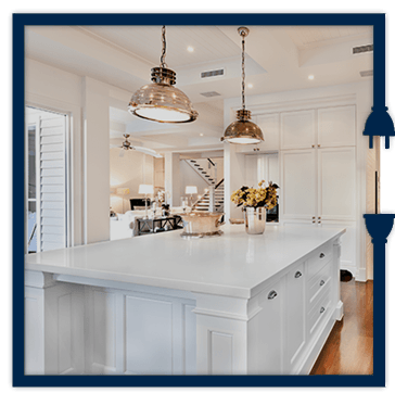 A kitchen with white cabinets and a large island in the middle