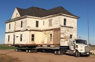 House being Moved by a White Truck — House Lifting in Moundridge, KS