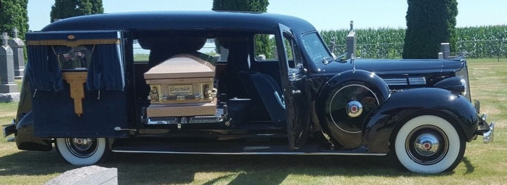 A black funeral car with a coffin inside of it