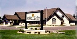 A large white building with a sign in front of it.