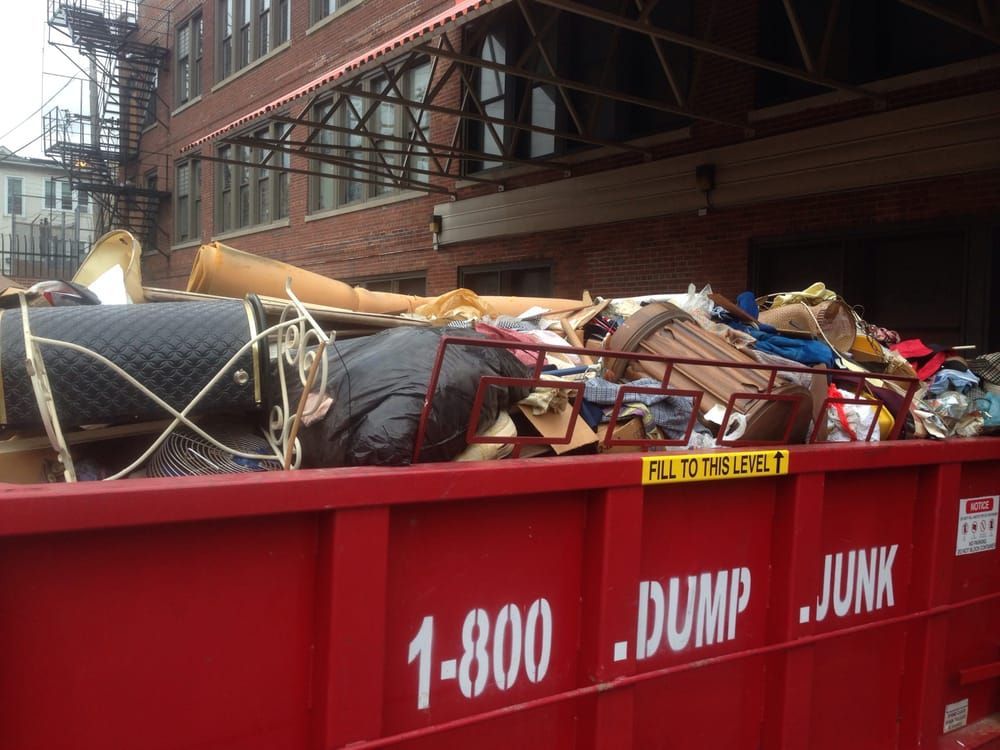 A bulldozer is scooping dirt from a parking lot.