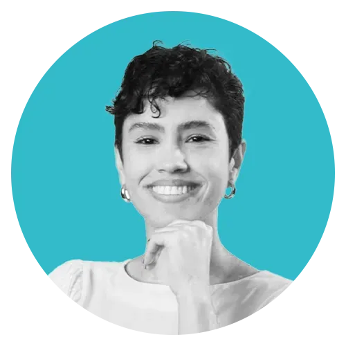 Uma foto em preto e branco de uma mulher sorrindo com a mão no queixo.