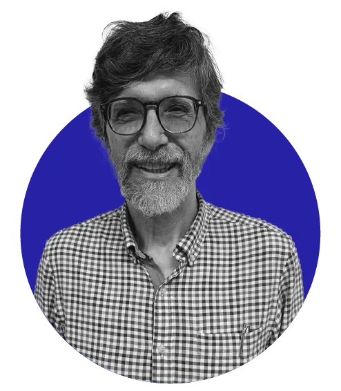 Um homem de óculos e barba está sorrindo dentro de um círculo azul.