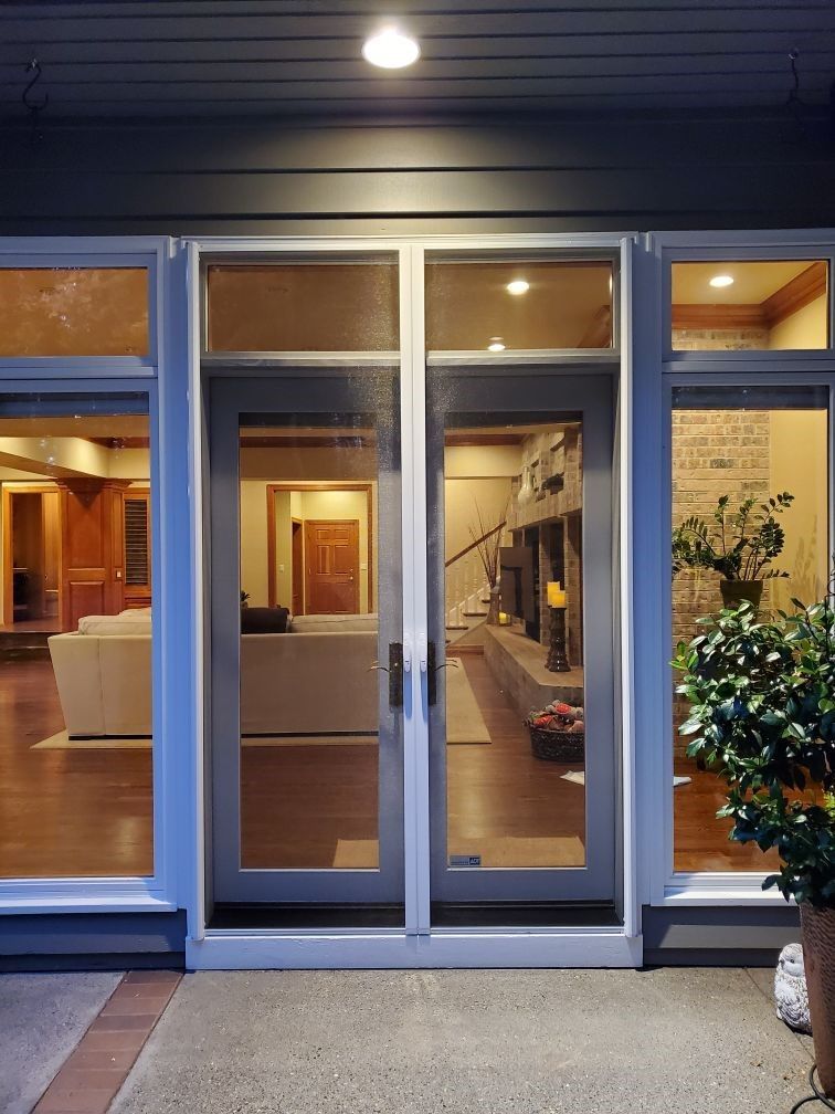 Sliding glass doors open to a warmly lit lobby with wood paneling and a potted plant.