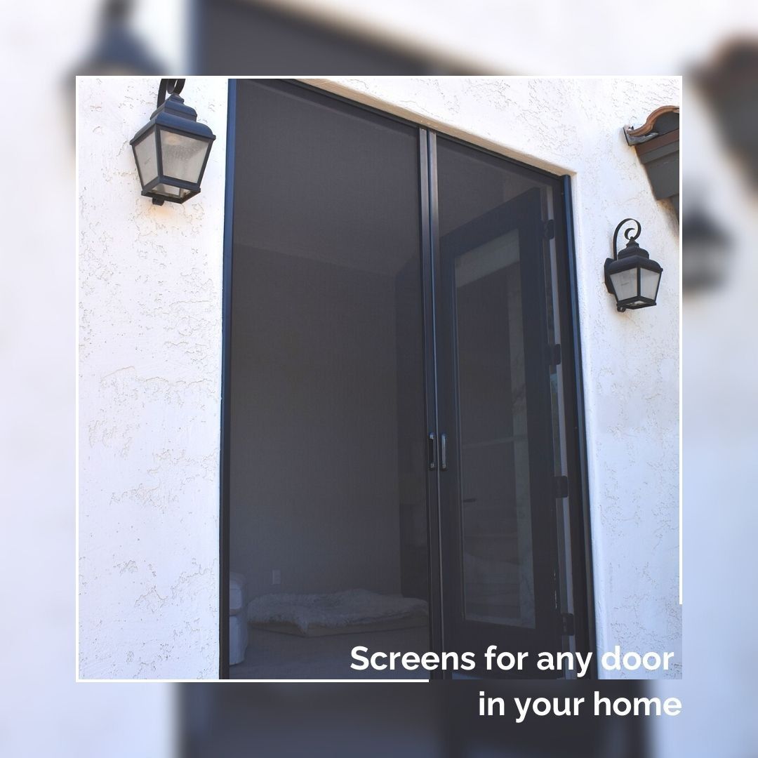 Black mesh screen door on a white stucco house, flanked by two wall lanterns.