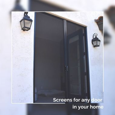 Black mesh screen door on a white stucco house, flanked by two wall lanterns.