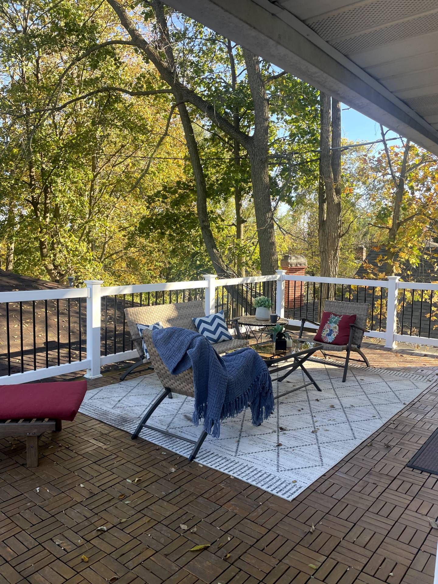A deck with a lounge chair and chairs on it