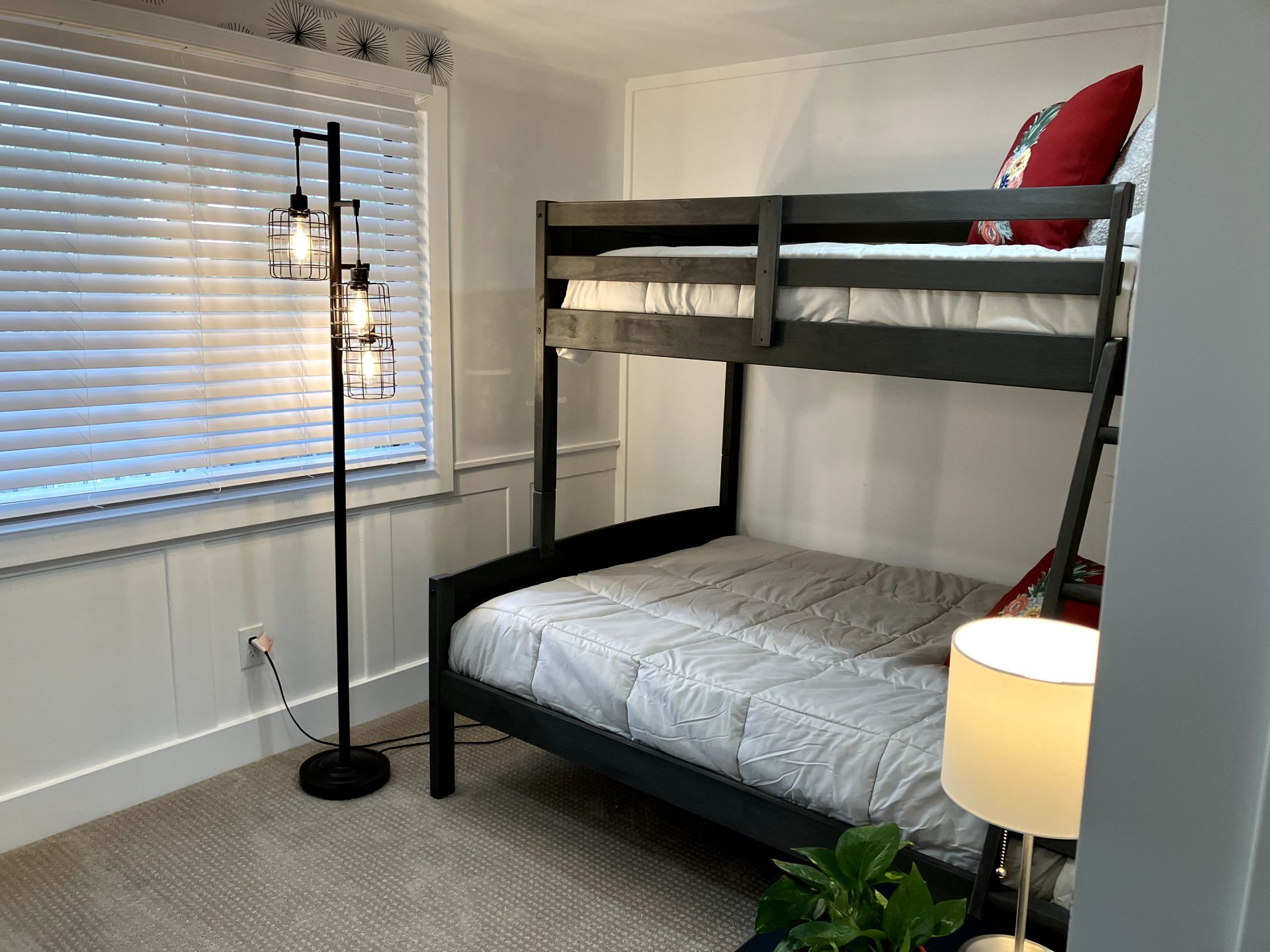 A bedroom with a bunk bed and a lamp.