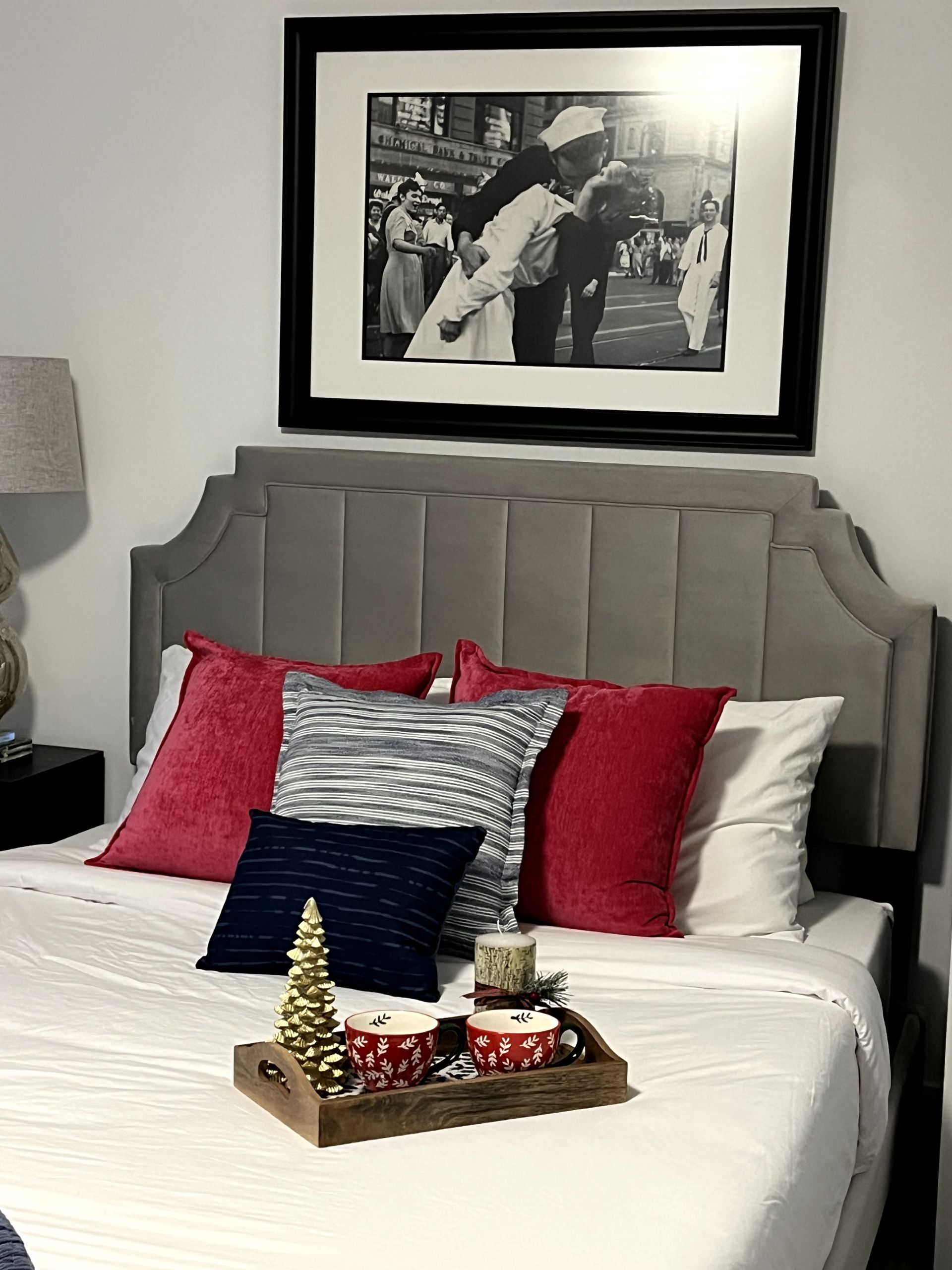 A bed with pillows and a picture on the wall above it