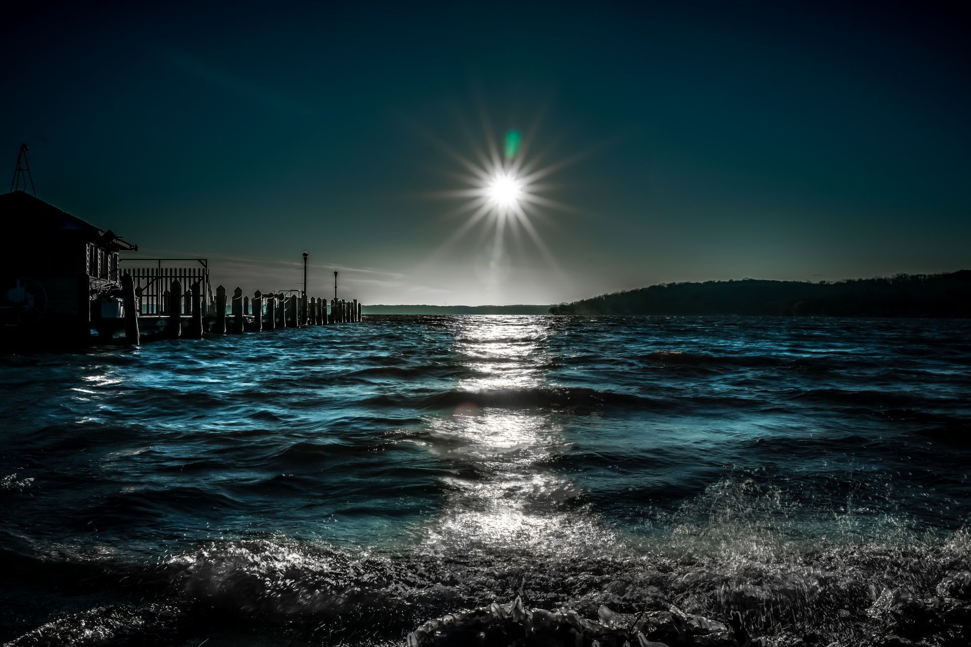 The sun is shining brightly over the ocean at night.