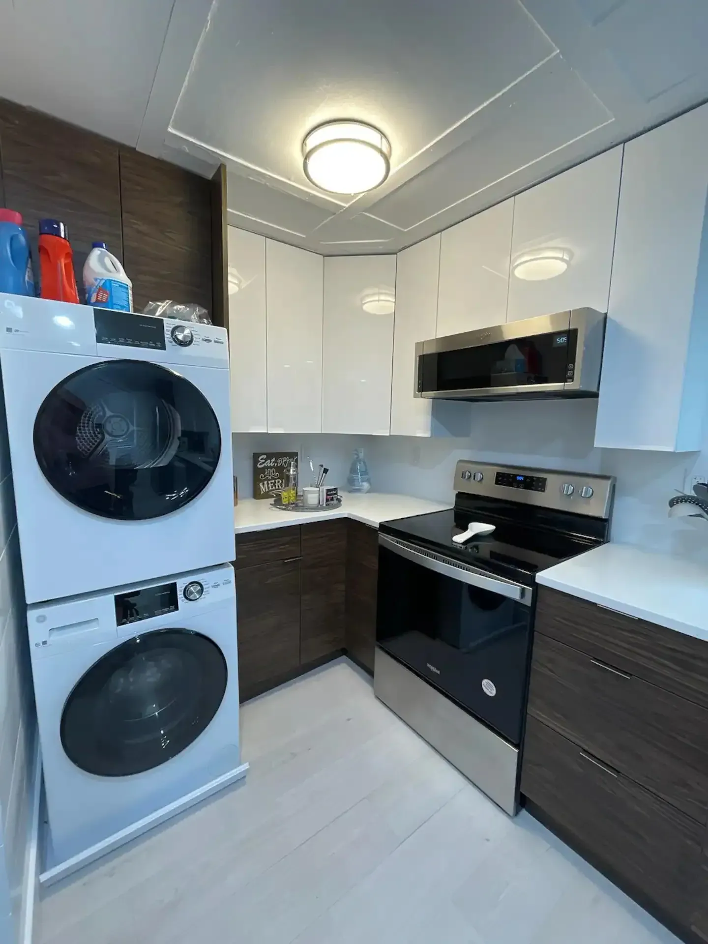 A kitchen with a washer and dryer stacked on top of each other.