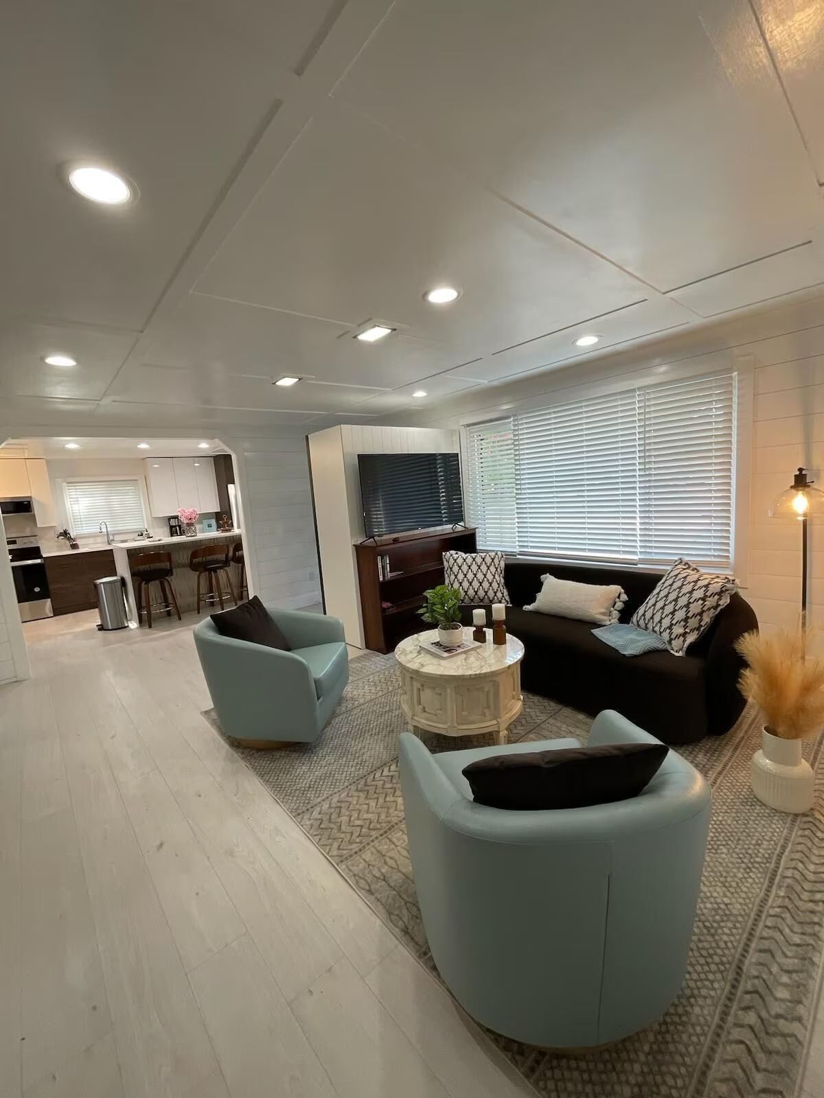 A living room with a couch , chairs , and a coffee table.