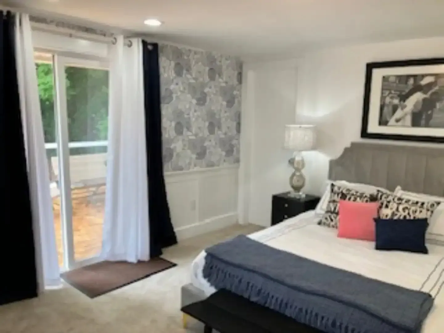 A bedroom with a large bed and a sliding glass door