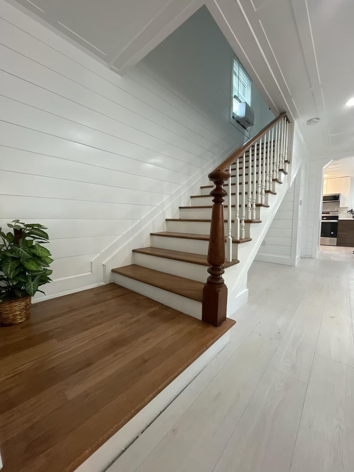 A staircase with wooden steps and a white railing in a house.