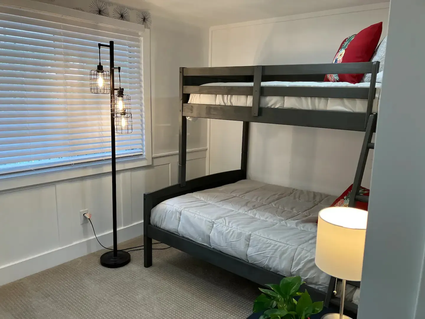 A bedroom with a bunk bed and a lamp.