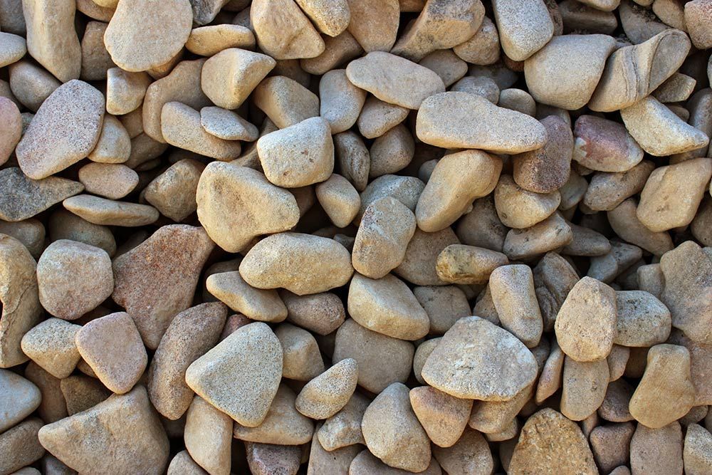 A Pile of Rocks is Sitting on Top of Each Other A Blood & Bone Plus Fertilizer — Caloundra Landscape Supplies in Warana, QLD
