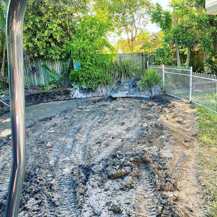 A Muddy Yard With a Fence and Trees in the Background — Caloundra Landscape Supplies in Caloundra, QLD
