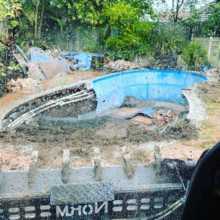 A Blue Swimming Pool is Being Built in a Backyard — Caloundra Landscape Supplies in Caloundra, QLD