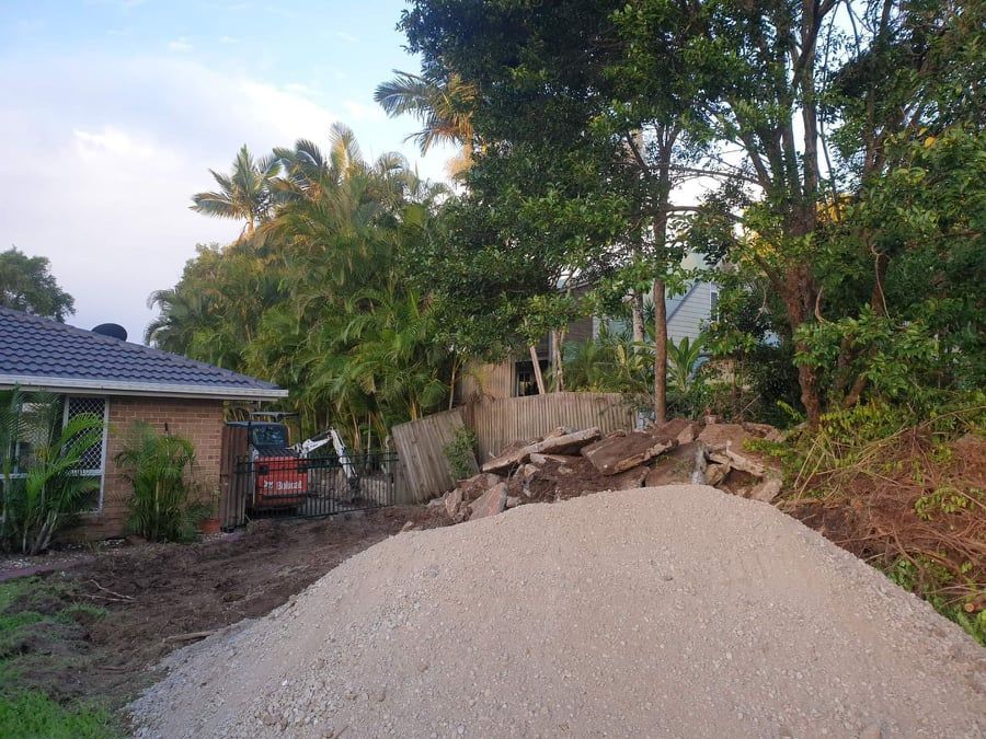 A Pile of Gravel is Sitting in Front of a House — Caloundra Landscape Supplies in Caloundra, QLD