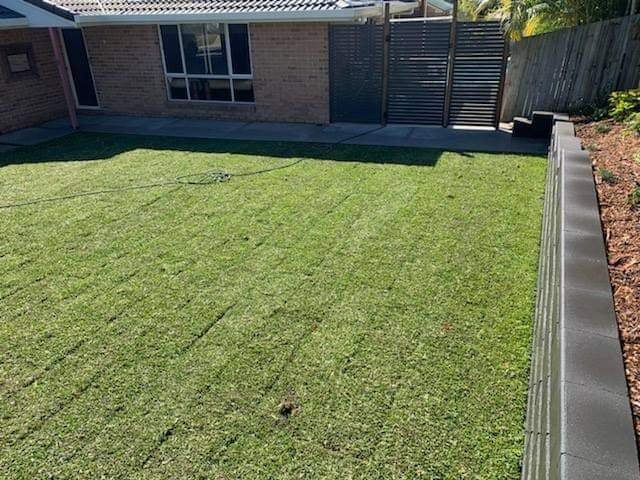A Lush Green Lawn in Front of a Brick House — Caloundra Landscape Supplies in Caloundra, QLD