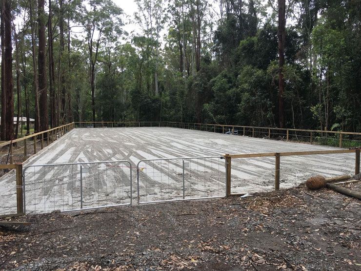 A Large Concrete Area Surrounded by Trees and a Wooden Fence — Caloundra Landscape Supplies in Caloundra, QLD